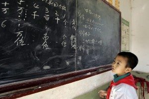 Recurso de archivo. Un niño chino en la pizarra, estudiando matemáticas