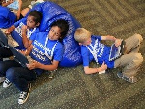 Varios niños interactuando con tabletas y punteros